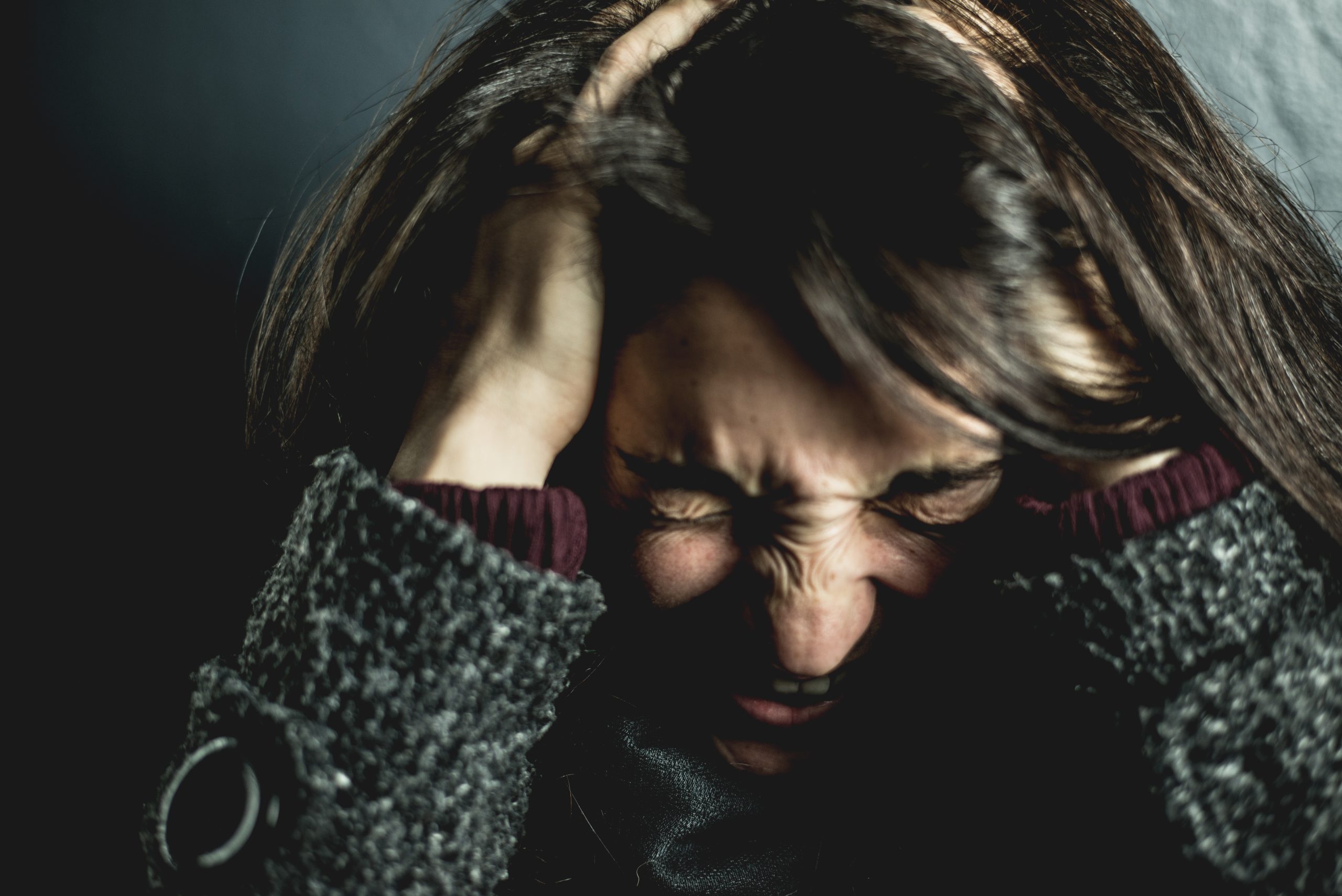 Distressed woman holding her head with her hands due to anxiety